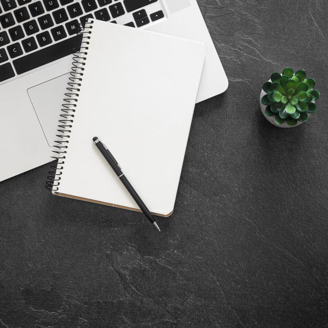 Arbeitsmaterialien auf einem Schreibtisch – Notebook, Notizbuch und Stift als Symbol für digitale Planung und Struktur