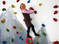 CVJM Waterdelle Borkum - Sportkeller - Kletterwand - Mädchen weit oben lächelt